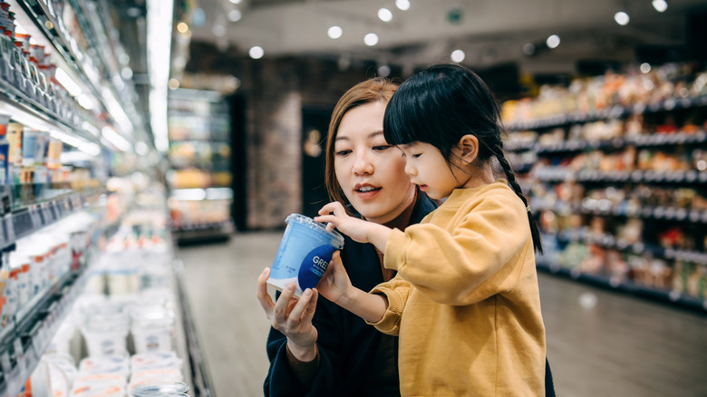 woman in supermarket looking at yogurt