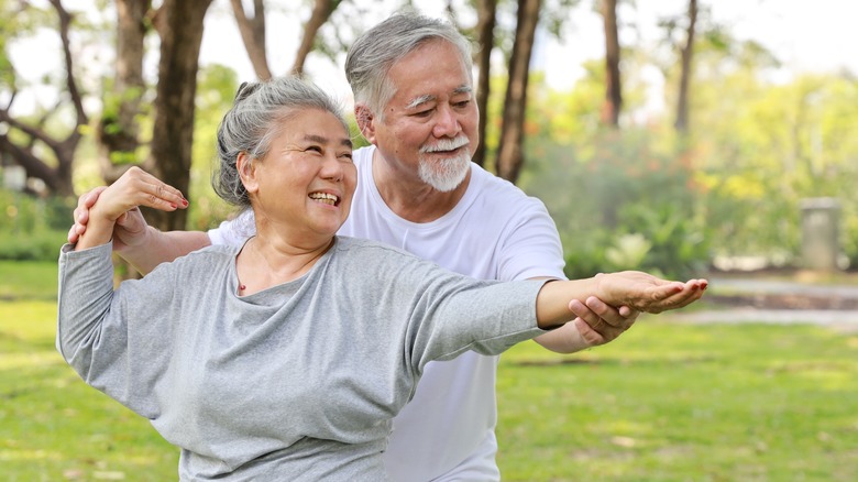 older couple practicing tai chi outdoors