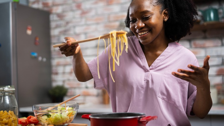 A woman cooking pasta in the kitchen