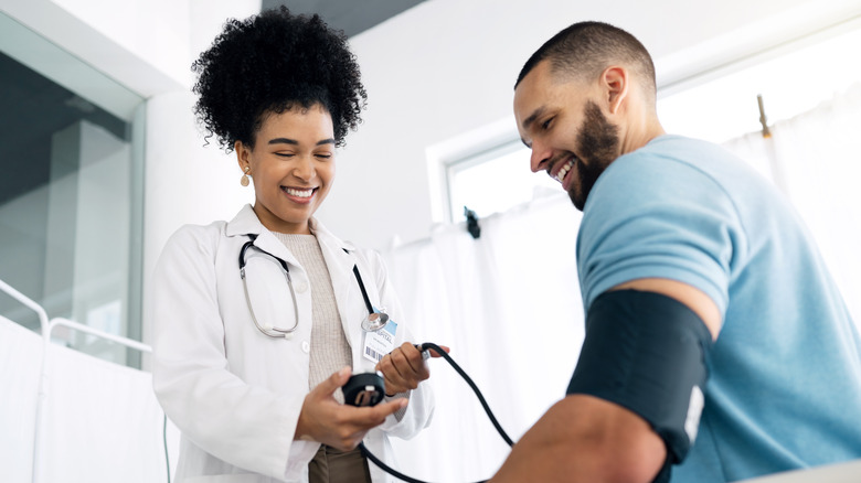 smiling patient as doctor takes blood pressure reading