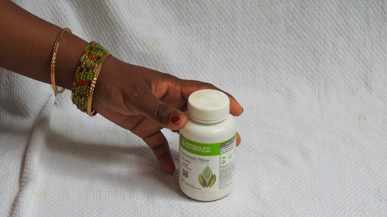 Person holding bottle of Herbalife Nutrition Activated Fibre product