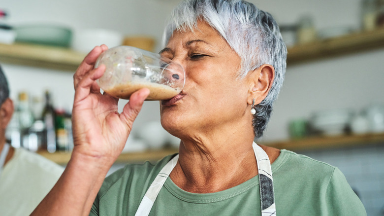 senior woman drinking last of a glass of smoothie