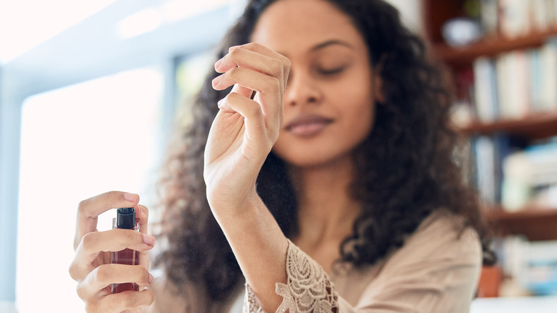 Woman applying perfume