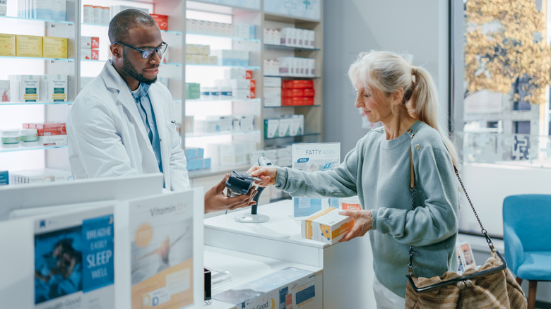 woman paying for medication at pharmacy