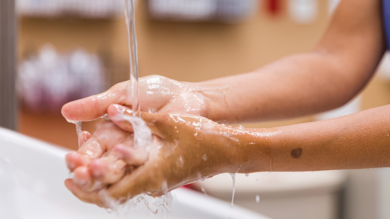 person washing hands after getting wound on fingers