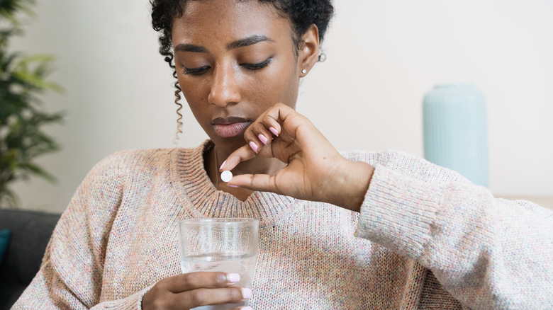 Woman taking vitamin D supplement