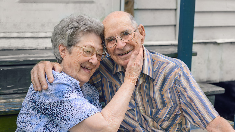 an elderly couple sitting outside 