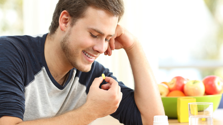 Male teen taking vitamin pill