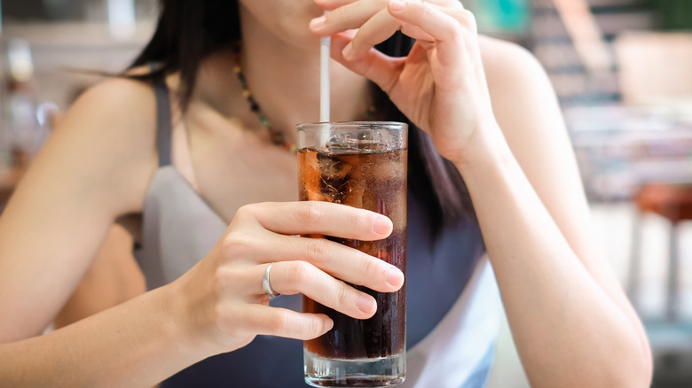 Woman drinking a glass of soda