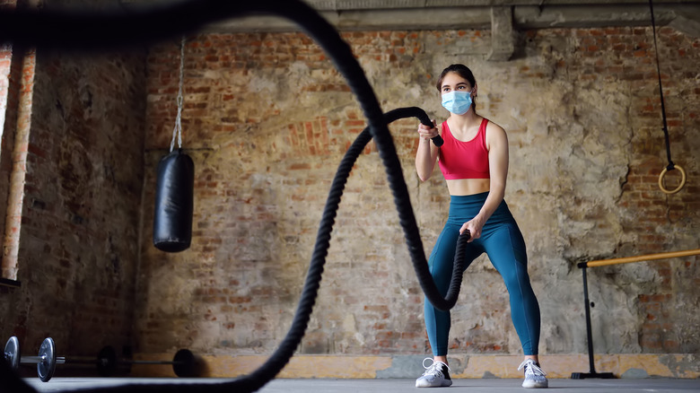woman using battle ropes at the gym
