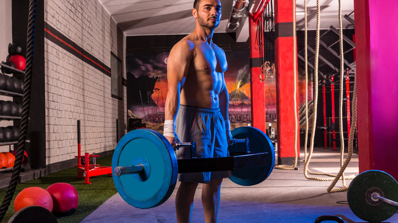 man holding barbell at the gym