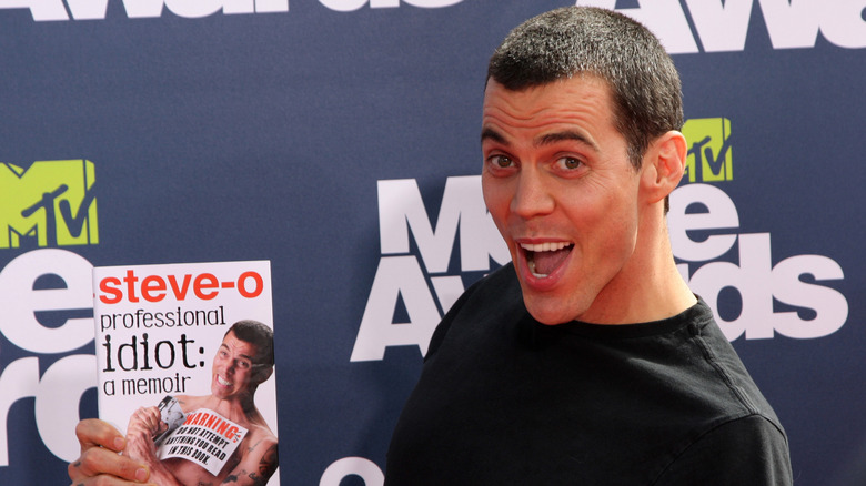 Steve-O holding his book
