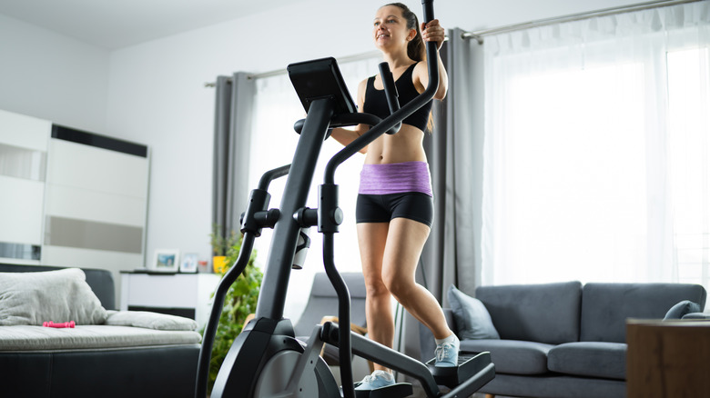 Woman On Elliptical Trainer At Home