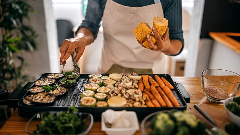 Person grilling vegetables