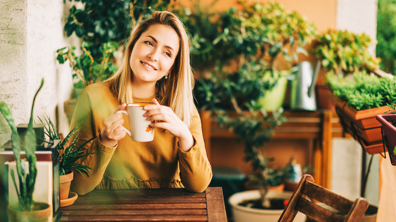 Woman drinking a cup of tea and smiling