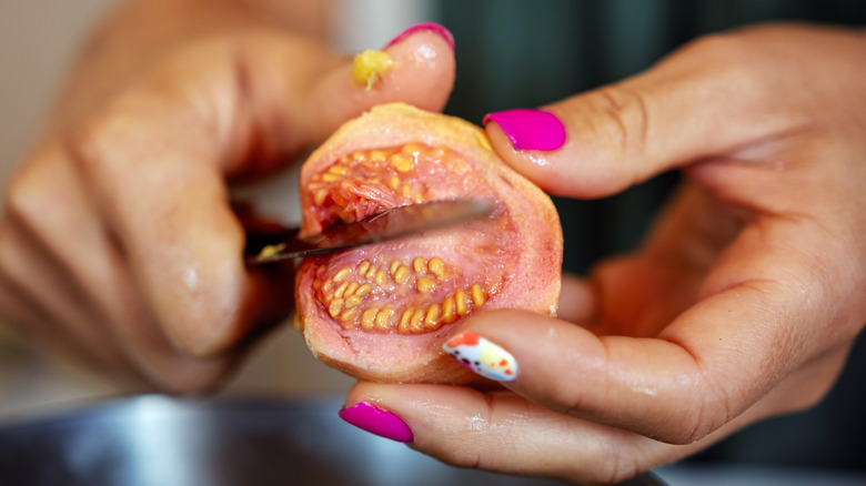 Woman cutting a guava