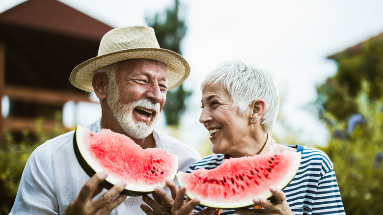 Happy couple eating watermelon together