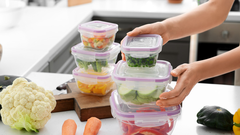 Woman holding plastic containers with vegetables