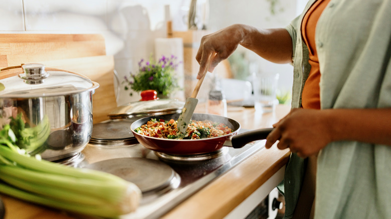 woman stirring healthy food in frying pan