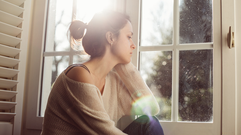 depresssed woman sitting near window