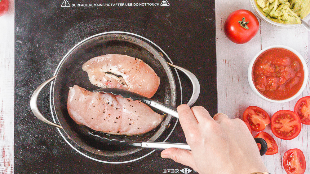 sauteing chicken in a pan for Costco keto-wrapped chicken burgers