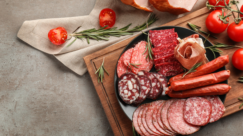 Plate with assorted deli meats on wooden board