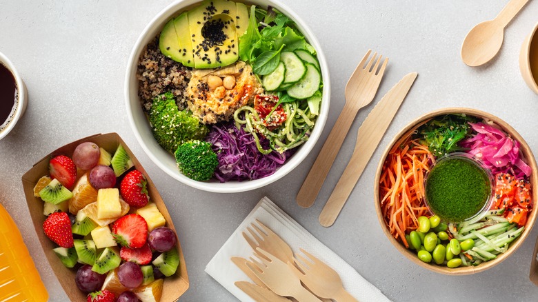 Top view of bowls with pre-cut veggies and fruit salad