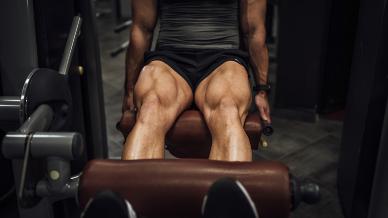 man working his quad muscles on a gym machine