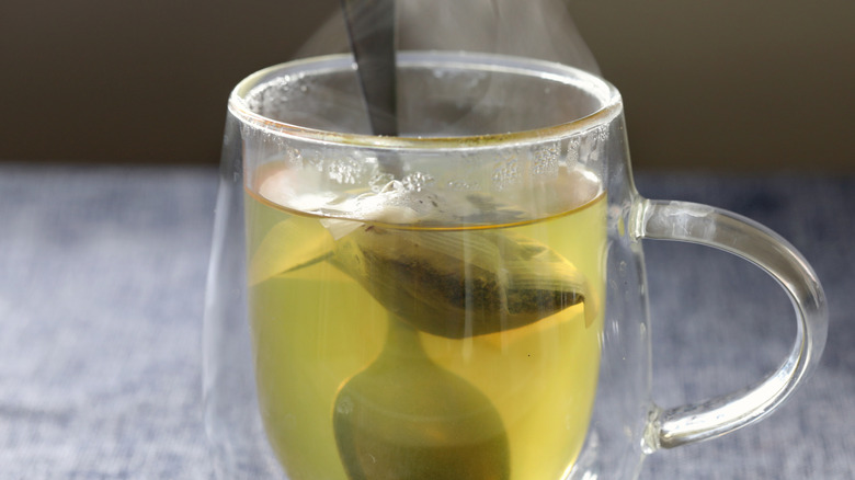 Green tea in a glass mug sitting on a table