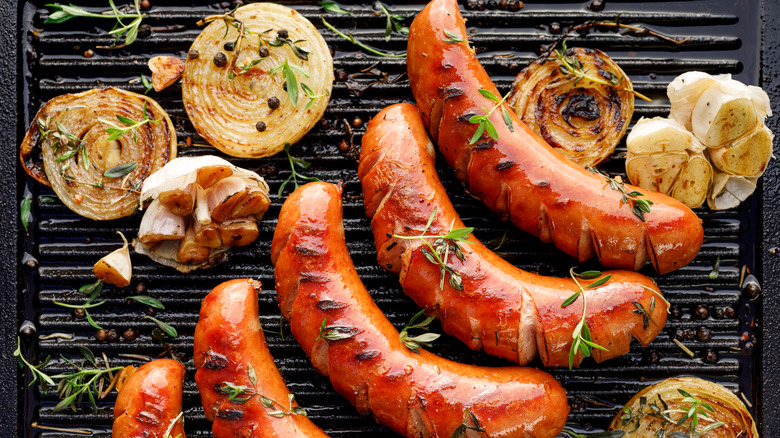 processed sausages and onions on an electric grill