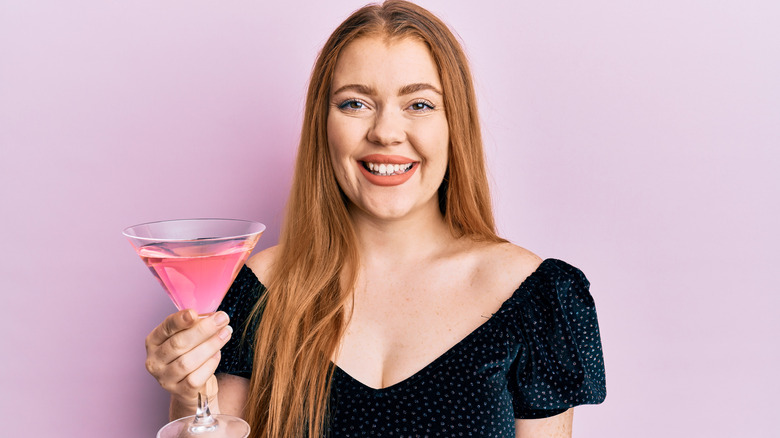 smiling woman holding cocktail