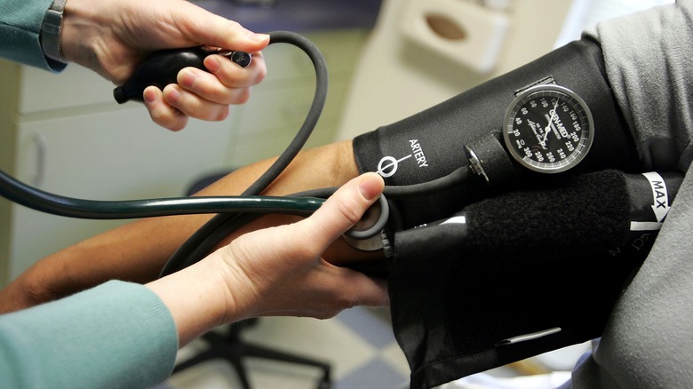 Doctor taking woman's blood pressure