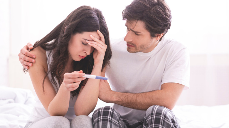 sad couple with negative pregnancy test