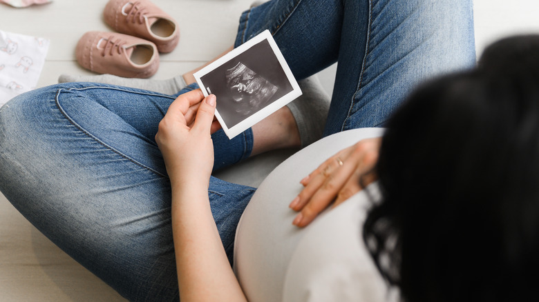 pregnant woman looking at ultrasound picture