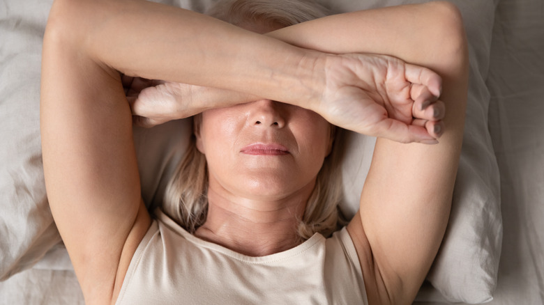 woman with migraine lying in bed