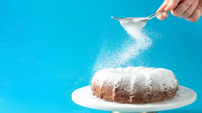 sprinkling sugar over a Bundt cake 