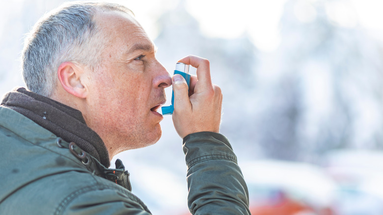 man using inhaler in winter