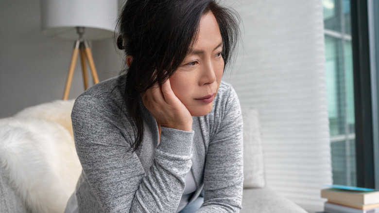 woman on couch looking sad