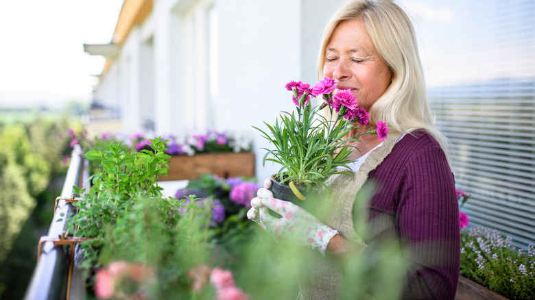 Woman in 50s smelling flowers