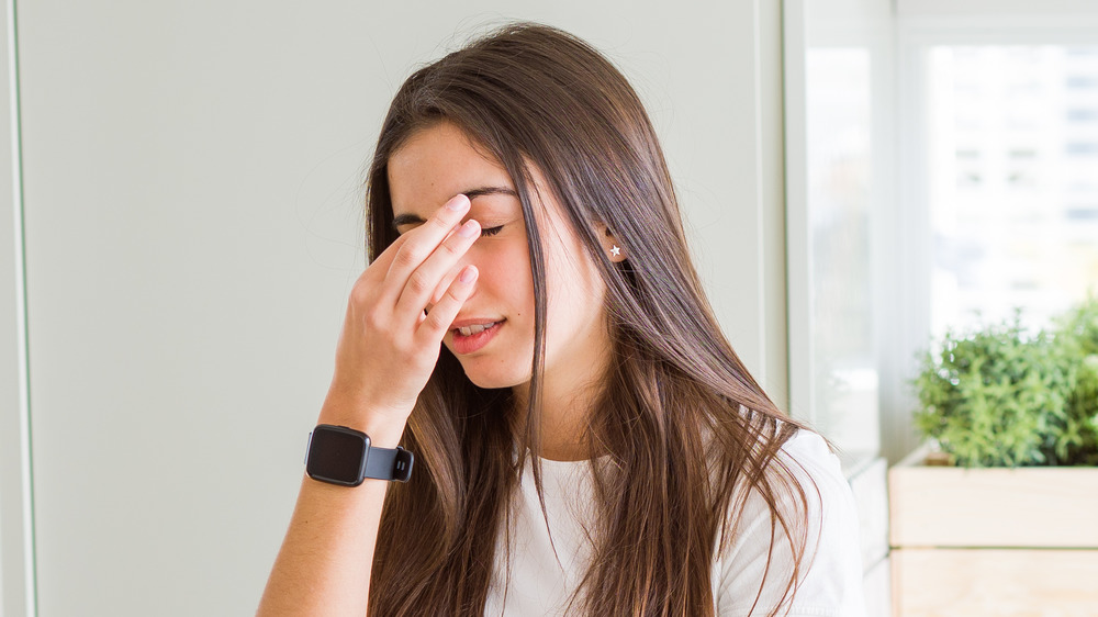 woman pressing pressure points on face