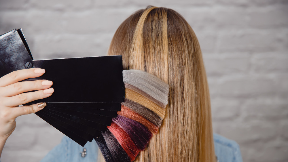 Back of woman's head with hair dye color choices