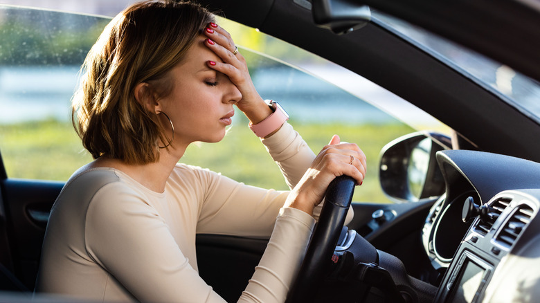 woman holding head from feeling sick