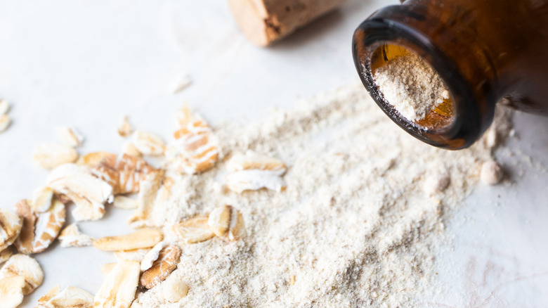 ground oatmeal spilling out of a brown bottle