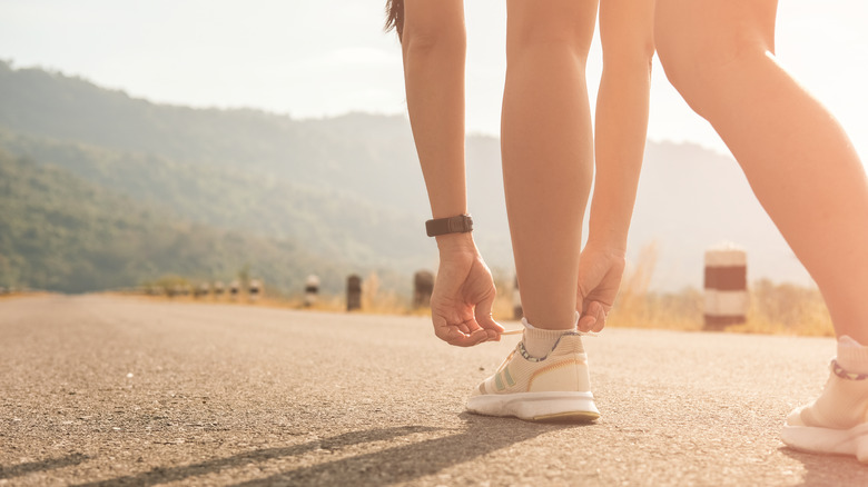 woman getting ready for morning walk tying her shoes