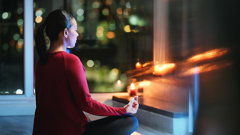 woman meditating at night in her room