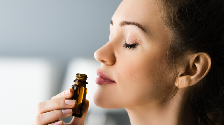 woman enhaling essential oil for aromatherapy