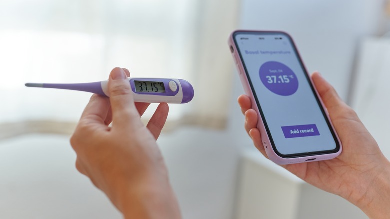 woman taking her temperature to track fertility