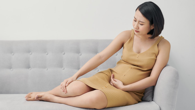 woman on couch resting swollen feet