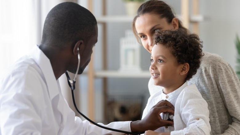Man checking child with stethoscope