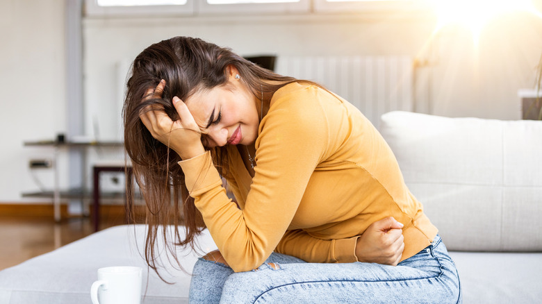 Woman holding stomach in pain